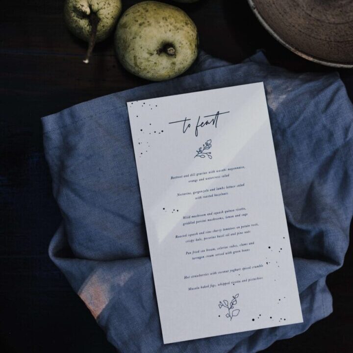 A menu sitting on top of a table next to apples.